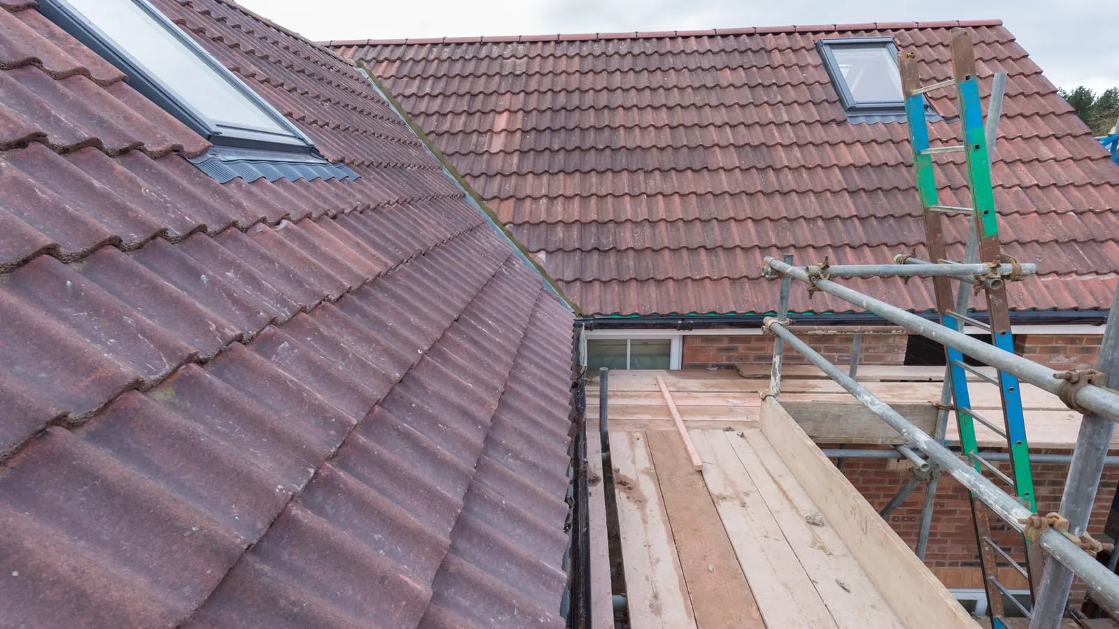 A finished tiled roof with rooflights, seen from the scaffold