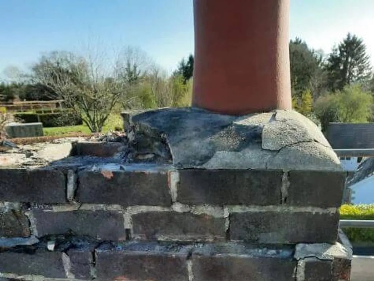 A brick chimney stack part way through being repointed