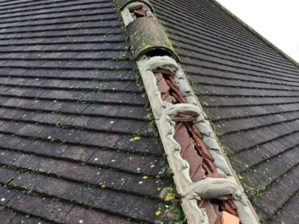Storm damage on a roof, with broken slates left lying across the covering