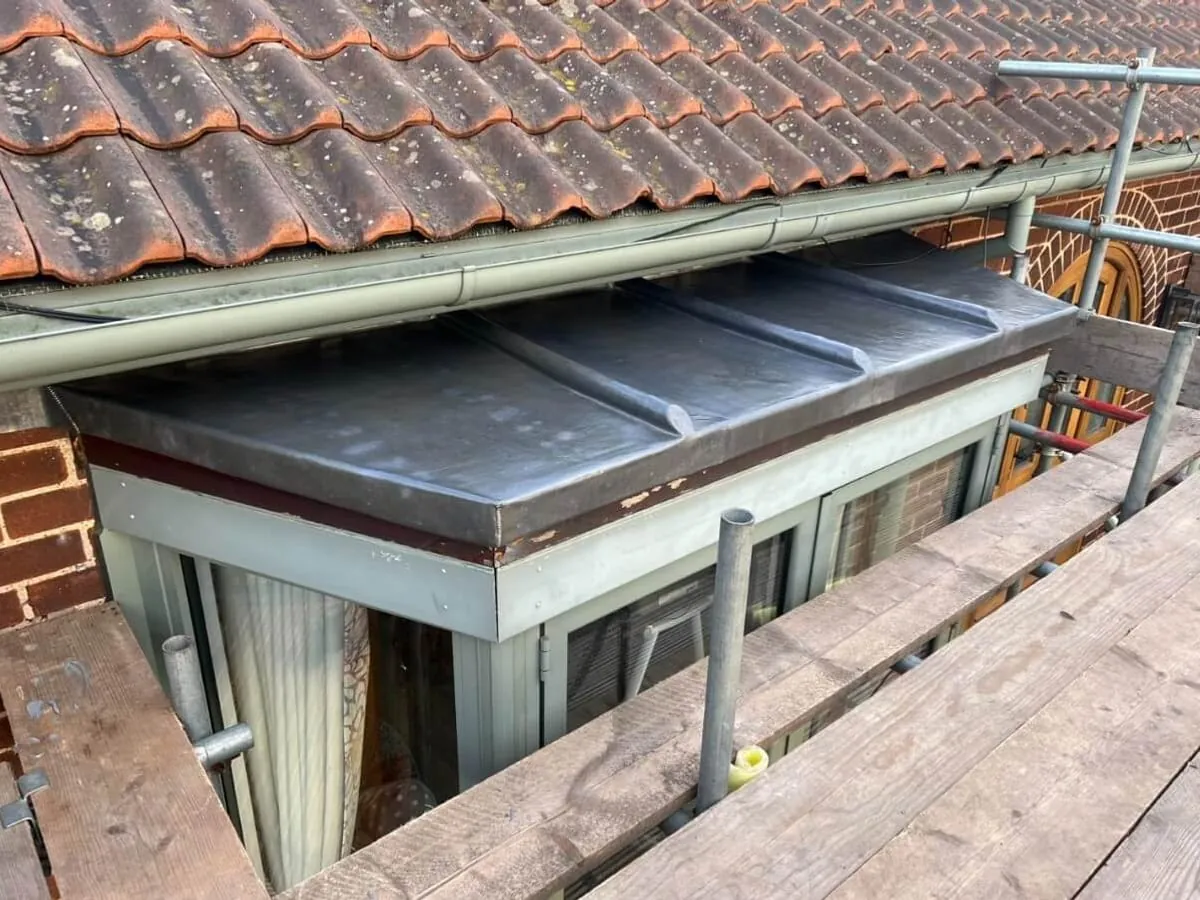A white fascia and grey guttering fitted to a bay roof with the scaffold still up