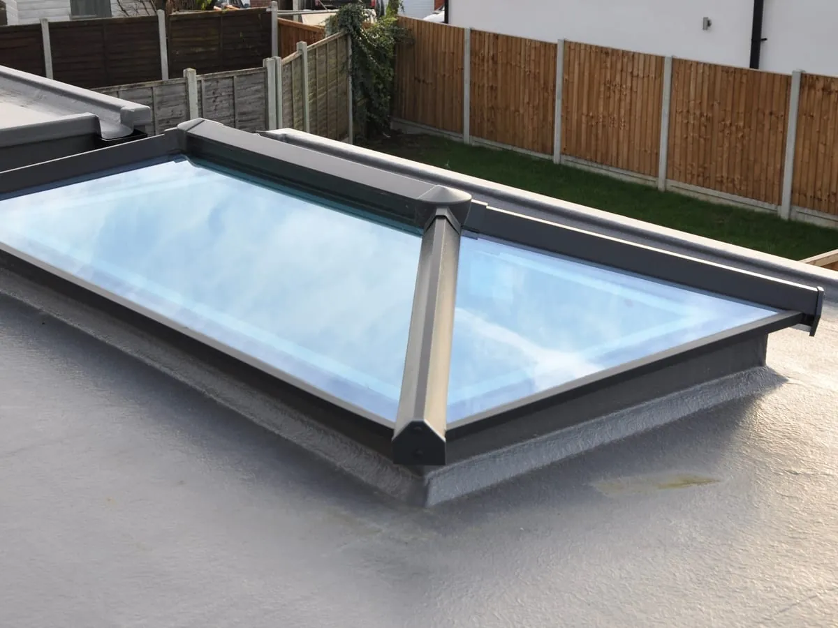 A finished grey GRP flat roof with a glazed lantern rooflight set into it