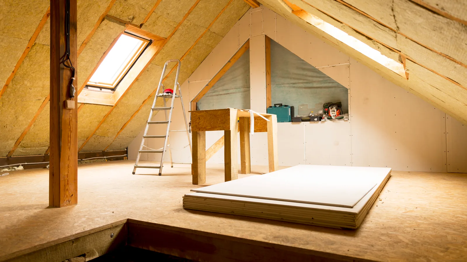 A loft space with the rafters and purlins exposed above mineral wool insulation
